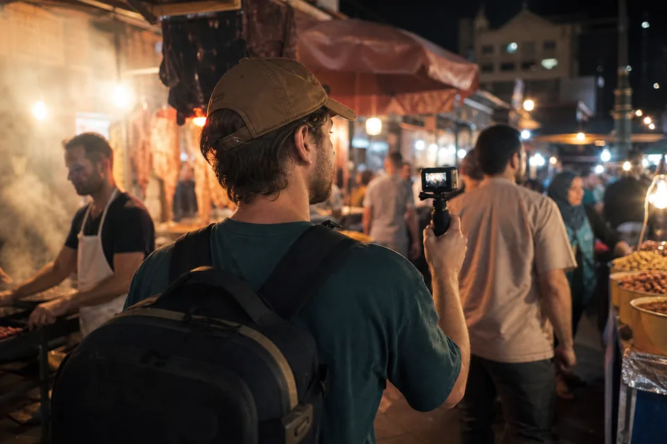 A travel vlogger filming himself at a night market